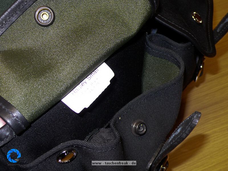 BILLINGHAM HADLEY SMALL\n\nFoto und Text von Jrg Langer - www.taschenfreak.de\n\nKommentar:\n\nDie kleinste Billingham aus der bekannten Hadley Serie. Typisch fr Billingham, der edle aber sehr robuste Stoff, die unauffllige "Bauform", die Lederbeschlge fr den Verschluss und der grne "Innenraum" der sehr weich und schtzend fr die edlen Teile darin ist.\n\nDie "Small Hadley" ist ideal fr eine kleine DSLR wie D40 oder D90 mit einem Kit oder Zoom bis max 18-200 VR oder ideal fr eine Systemkamera mit angesetzten Objektiv und einem weiteren Objektiv. Hinter dem Fotofach ist ein weiches flaches Fach zu finden welchen wirklich perfekt zugeschnitten fr das iPad ist und die beiden Fronttaschen nehmen gut Handy, Ersatzakku, Camera Connection Kit fr das iPad oder auch Geldbrse auf. \n\nDie Tasche ist sehe edel verarbeitet, dennoch praktisch und bequem zu nutzen. Der Gurt st fest und nicht abnehmbar und leider recht rutschig auf der Jacke. Dagegen hilft das optionale Schulterpolster fr den Gurt (das ich leider nicht mitbestellt habe....).\n\nAlso wer eine kleine Tasche fr seine kleinen Begleiter sucht wird mit der Hadley Small sicher sehr glcklich werden!