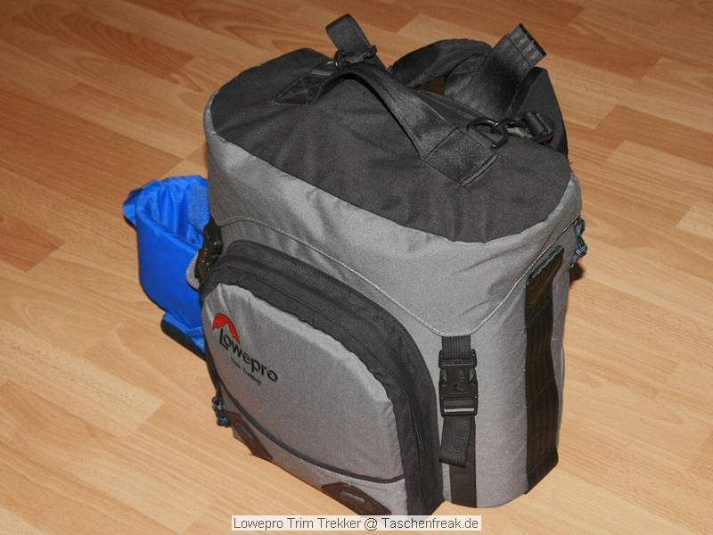 Lowepro Trim Trekker\n\nFoto von Thomas Brocher - VIELEN DANK THOMAS!\n\nKommentar des Nutzers:\n\nEs ist (soweit ich wei) das einzige Toploader-Modell am Markt. Damit meine ich, dass er auf seiner Unterseite abgestellt und dann von oben hinein gegriffen werden kann. Er muss also nicht hingelegt werden und die Tragegurte knnen so nicht verdreckt werden.\n\nPlatz hat er genug, es passt ins Hauptfach eine 1-er mit angesetztem 100-400, daneben noch 2 Objektive wie z.B. 17-40 und 24-85. Unter den beiden Objektiven kann ein Schubfach seitlich heraus gezogen werden um z.B. einen Blitz oder 2 kleinere Objektive al 1,4/50 untergebracht werden. Was allerdings nicht passt sind die langen Tele-Ls.\n\nIm Deckel kann Kleinkram wie Speicherkarten, Batterien o.. untergebracht werden.\n\nIn der Vordertasche passen Filter oder andere Kleinteile.